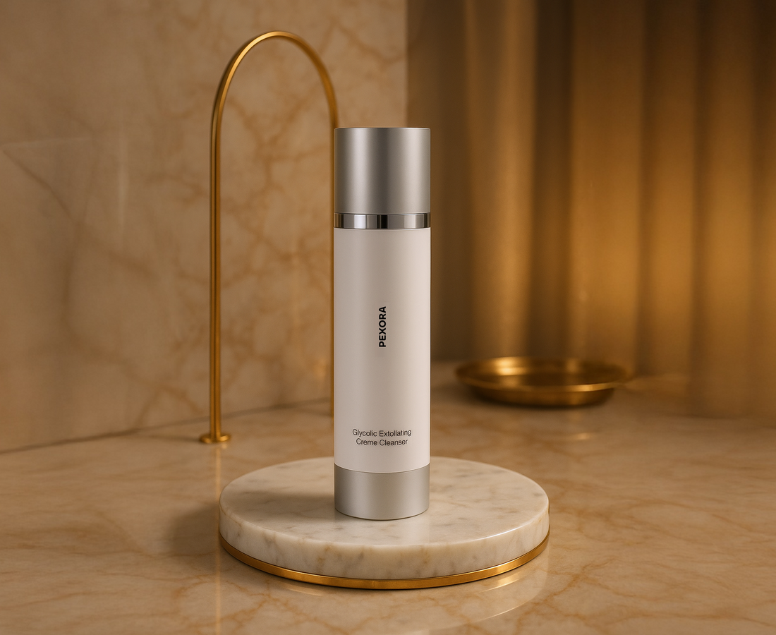 EXORA Glycolic Exfoliating Crème Cleanser displayed on a marble pedestal with a warm golden background, highlighting its luxurious skincare packaging